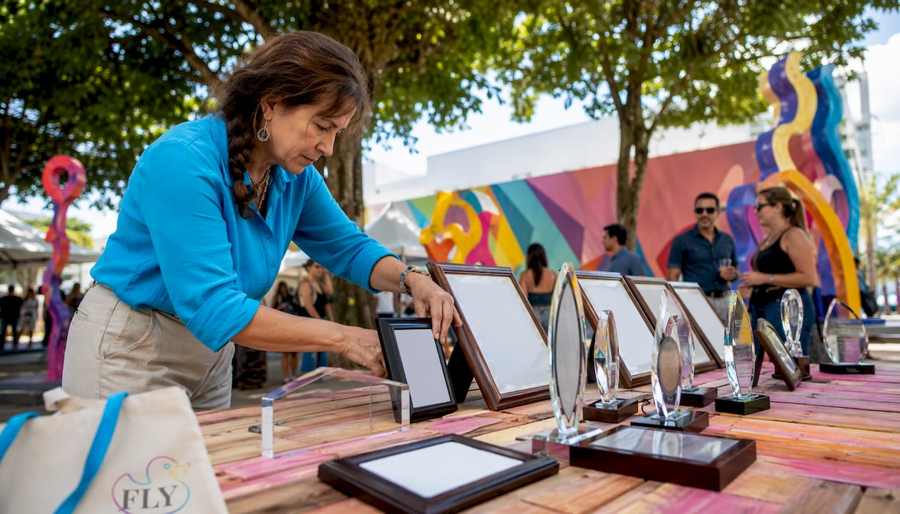 Gallery curator arranging award plaques