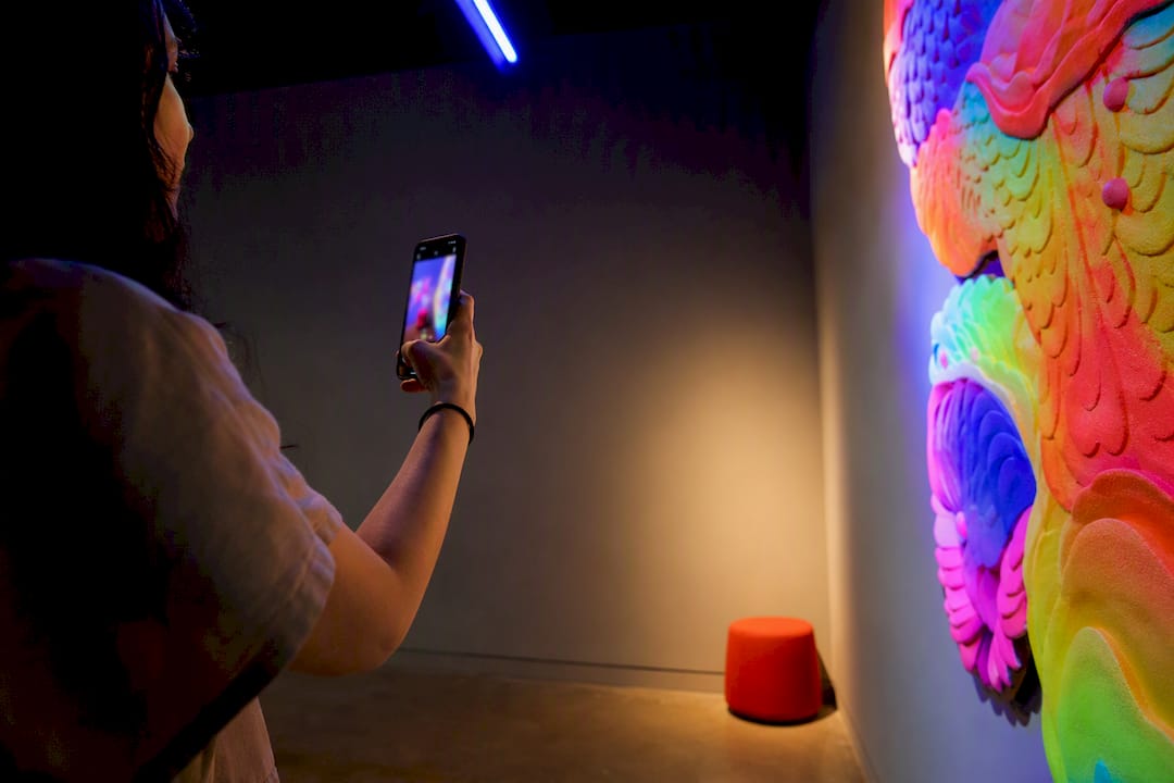 Visitor photographing glowing art installation