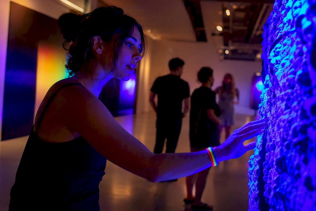 Visitors engaging with glowing art installation