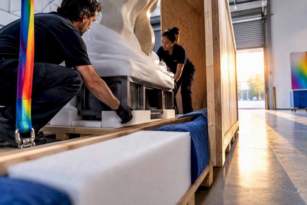 Sculpture being carefully lowered into shipping crate