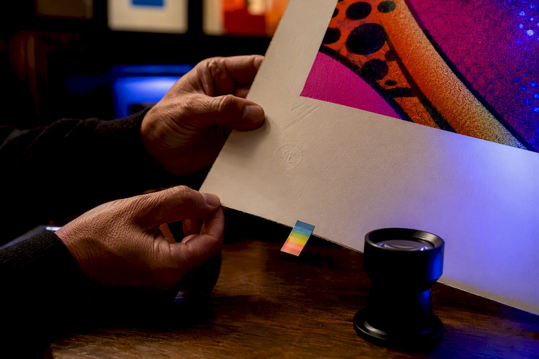 Collector examining an artist proof artwork detail