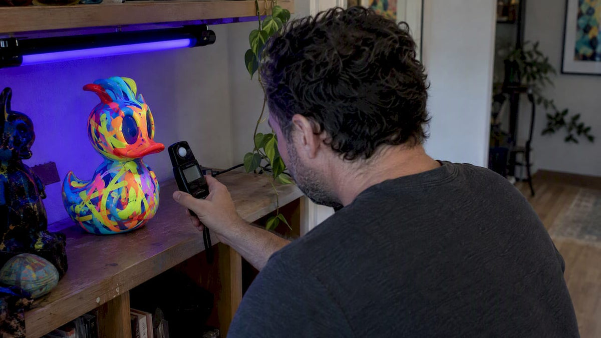 Collector measuring light beside a UV-reactive sculpture